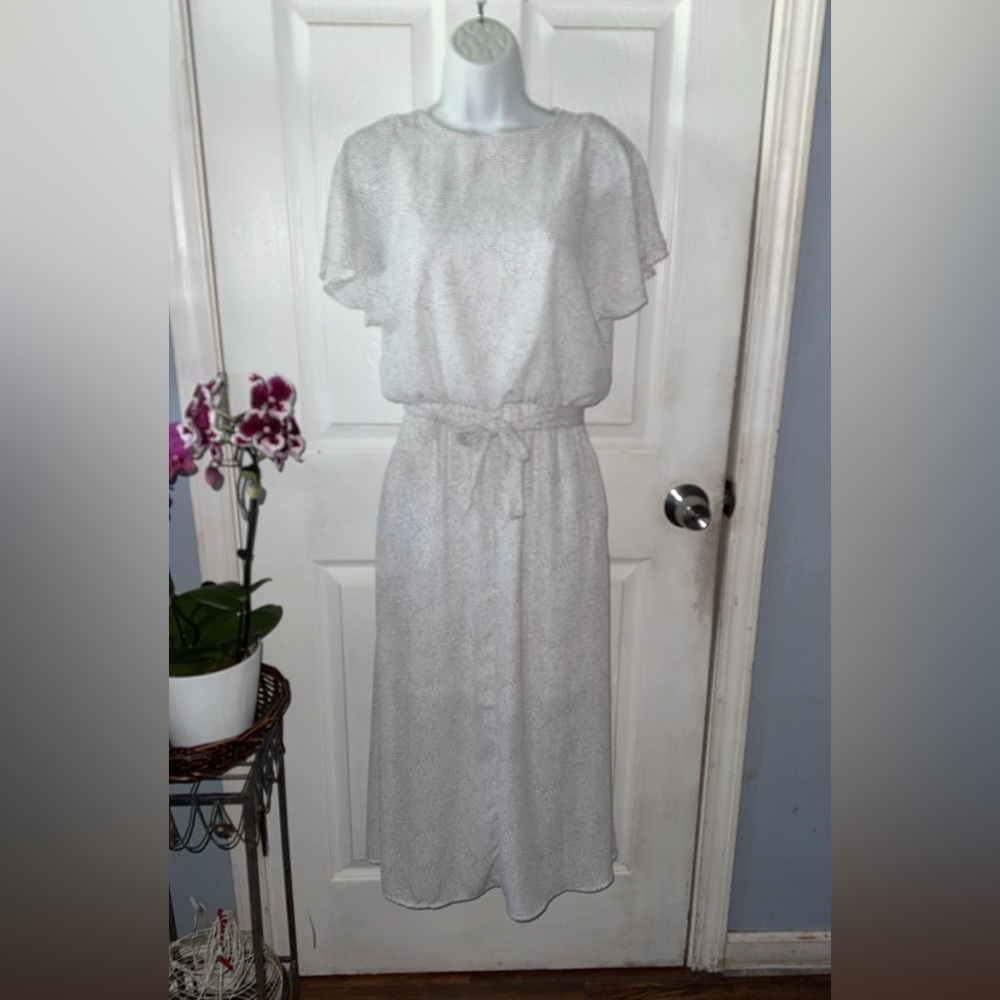 White dress with small black polka dots, also a belt